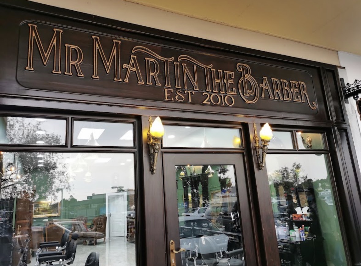 The carved timber shopfront of Mr Martin The Barber, est. 2010, at Bracken City Shopping Centre